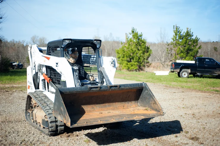 Skid steer with bucket attachment for finish grading