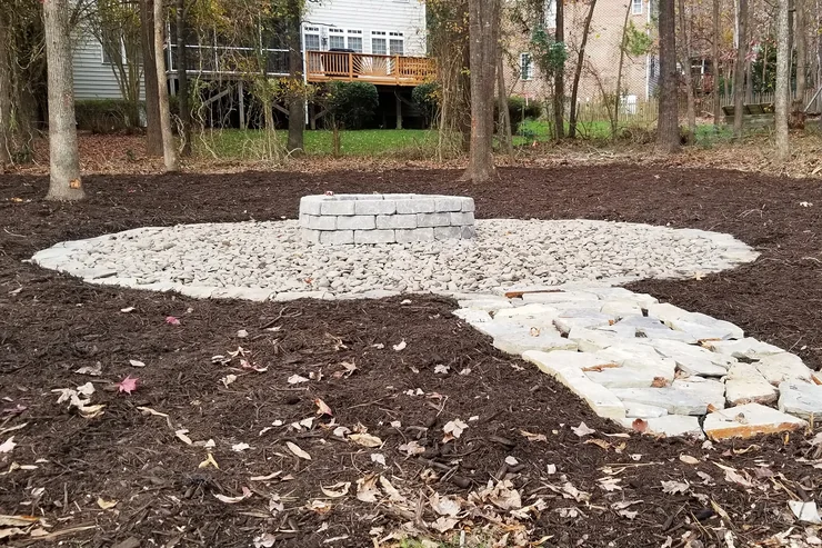 Custom stone fire pit with boulder seating area