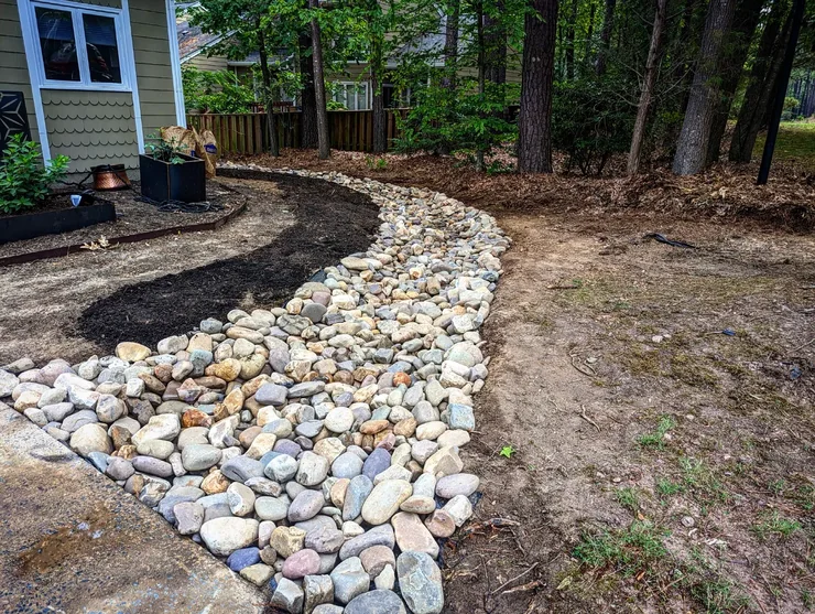 Stone creek bed winding through residential landscape